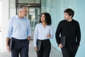 Three reviewers walk with folders while discussing google docs ai detector evidence on campus.