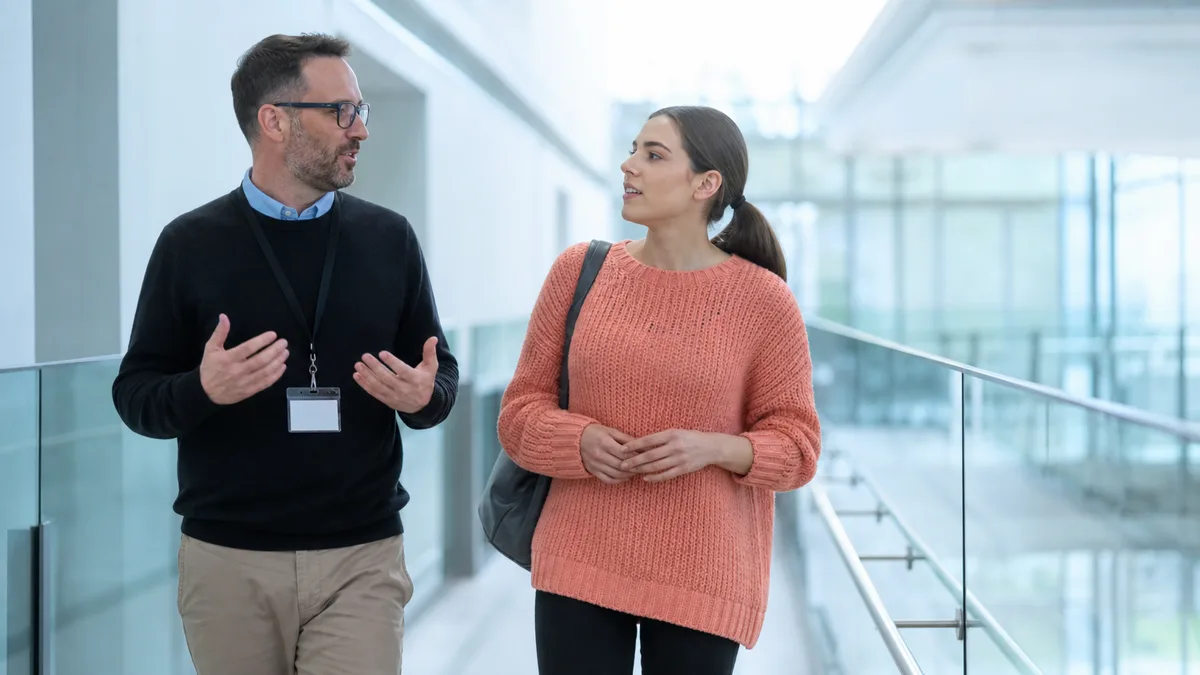 Advisor talks with student about an ai text detector in bright campus atrium