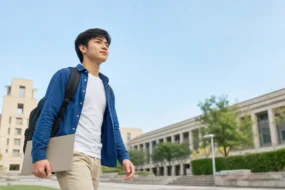 Student crossing a campus courtyard with a plain folder before checking a Turnitin AI score.