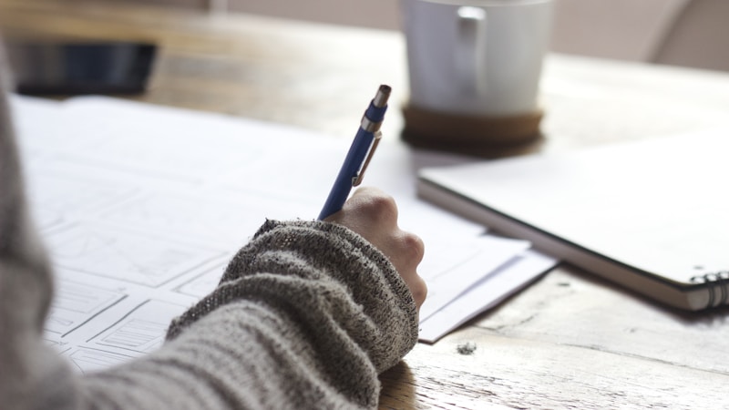 A desk with notebooks and a pen showing an academic writing scene, where Turnitin AI detection might flag Claude-generated text.